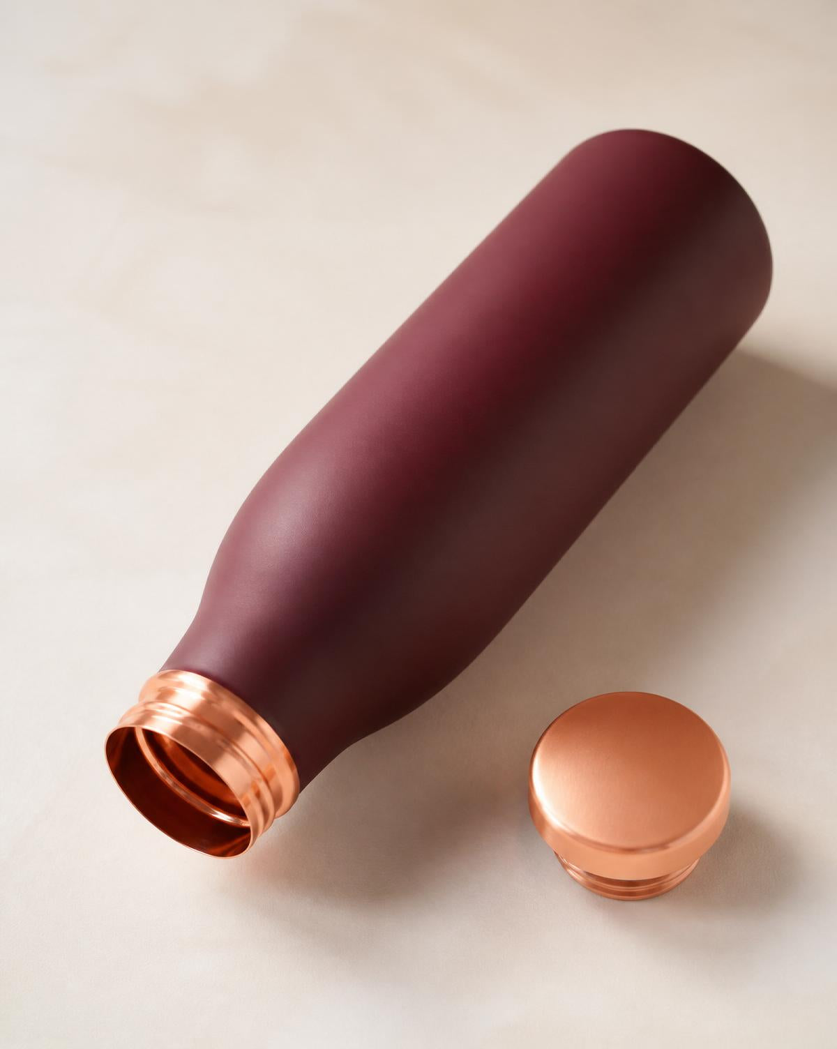 Maroon copper bottle with cap unscrewed